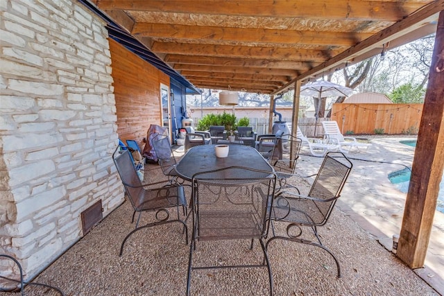 view of patio / terrace with outdoor dining area, fence, and visible vents