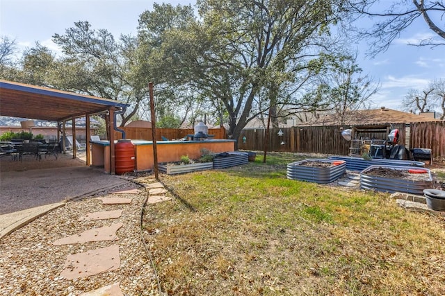 view of yard featuring a patio, a fenced backyard, and a garden