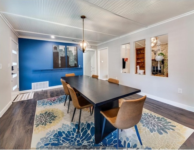 dining area with baseboards, wood finished floors, visible vents, and ornamental molding