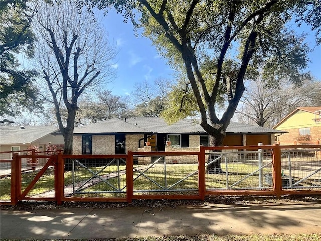 ranch-style house featuring a fenced front yard, stone siding, and a gate