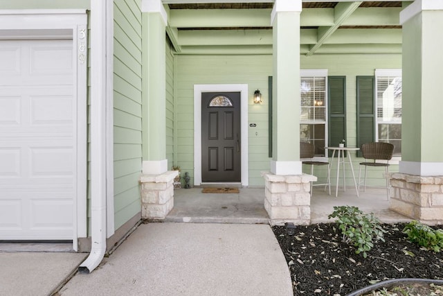 entrance to property with covered porch and a garage