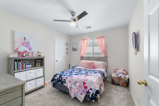 carpeted bedroom featuring a ceiling fan, visible vents, and baseboards