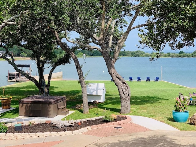 view of community with a lawn and a water view