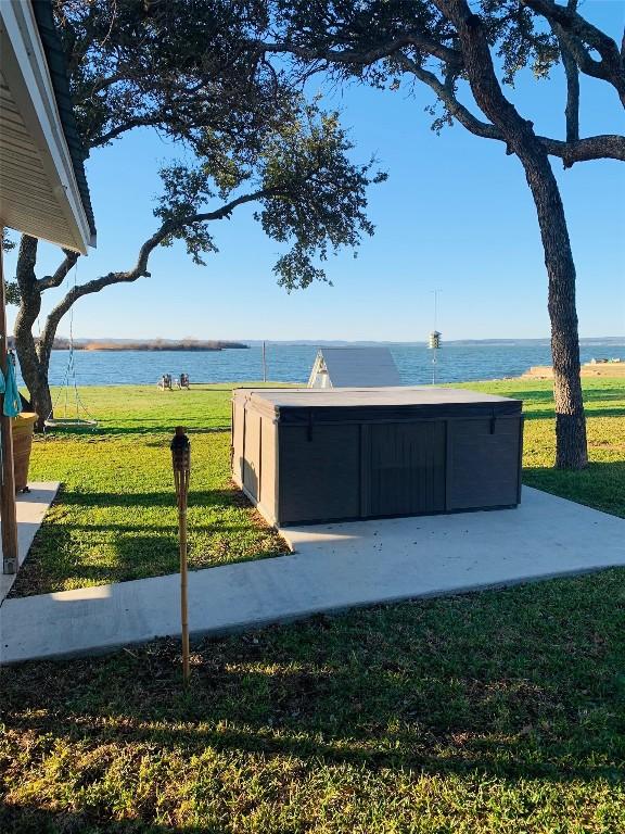 exterior space with a water view and a hot tub