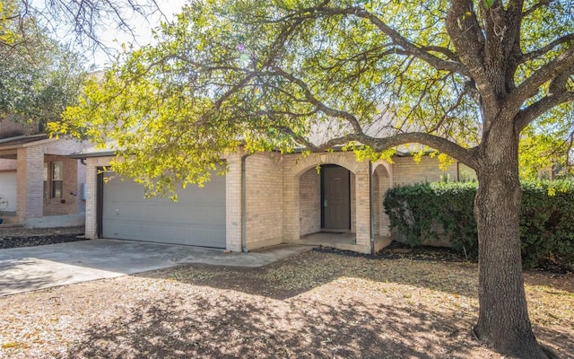 view of front of house with concrete driveway, brick siding, and an attached garage