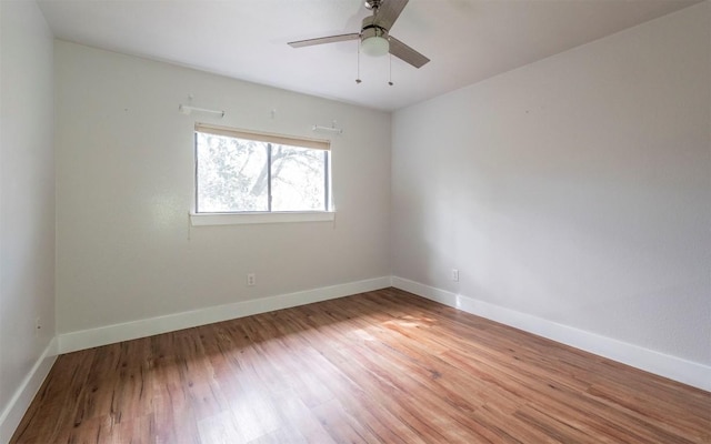 empty room featuring a ceiling fan, baseboards, and wood finished floors