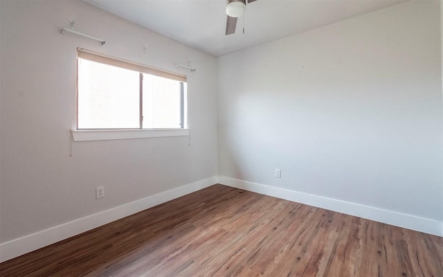 unfurnished room with wood finished floors, a ceiling fan, and baseboards