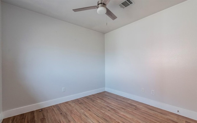 spare room with ceiling fan, light wood-type flooring, visible vents, and baseboards