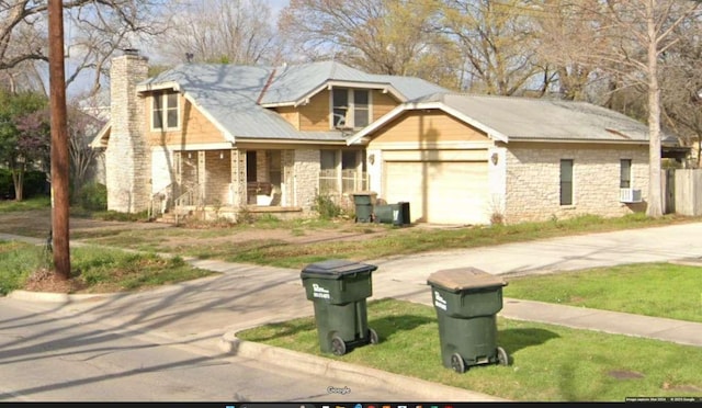 view of front of home featuring a garage, driveway, a chimney, and a porch