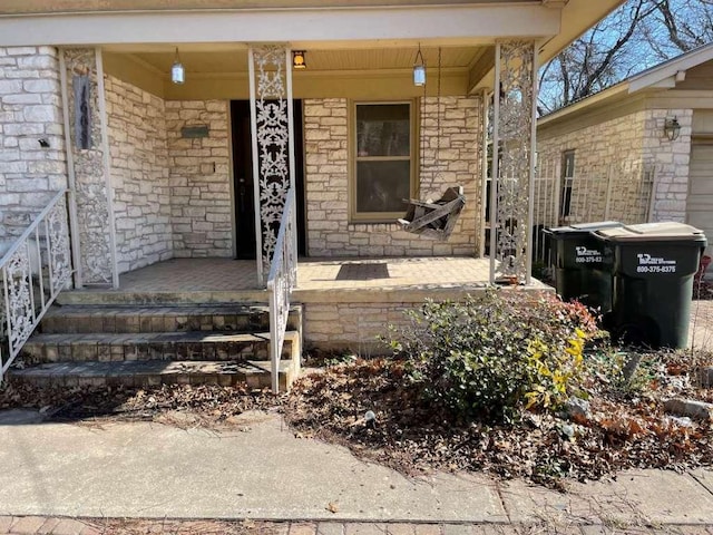 doorway to property featuring stone siding and a porch