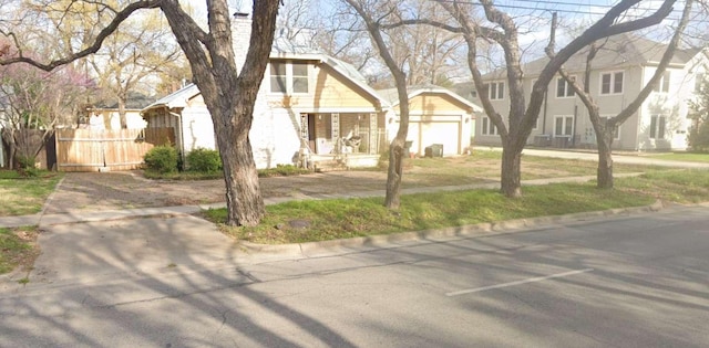 view of front of property with a front yard, fence, and an attached garage