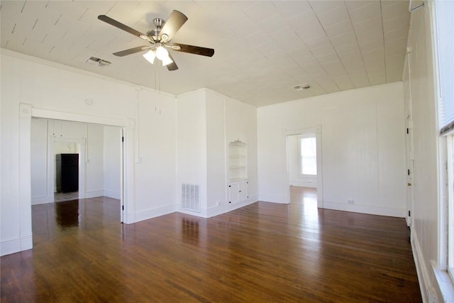 unfurnished room featuring built in features, visible vents, and wood finished floors