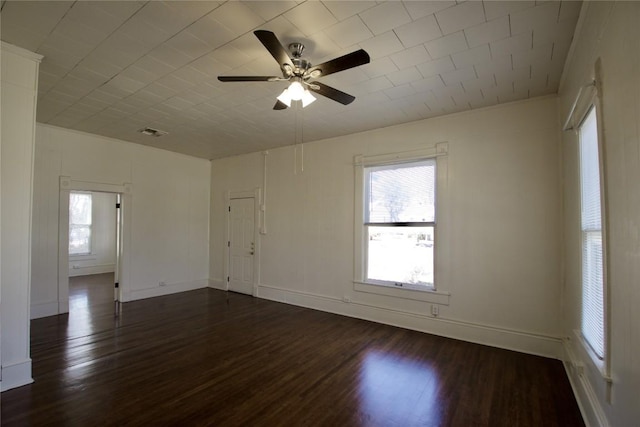 spare room with dark wood-style flooring, ceiling fan, and baseboards