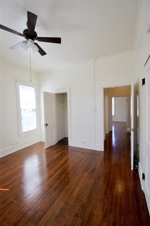 interior space with dark wood-type flooring, a closet, baseboards, and a ceiling fan