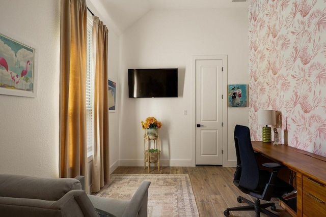 office space with lofted ceiling, wood finished floors, and baseboards