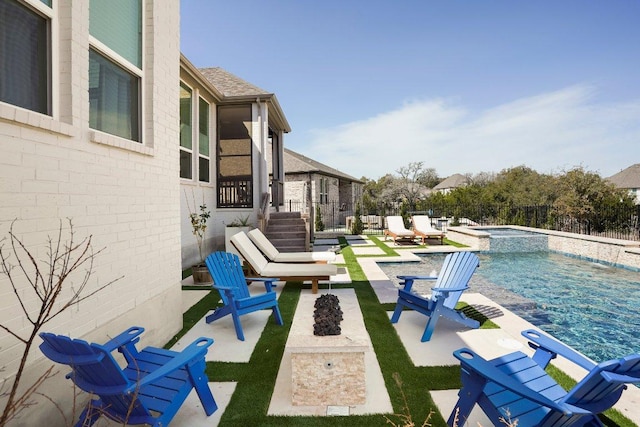 view of patio with an outdoor fire pit, fence, and a pool with connected hot tub