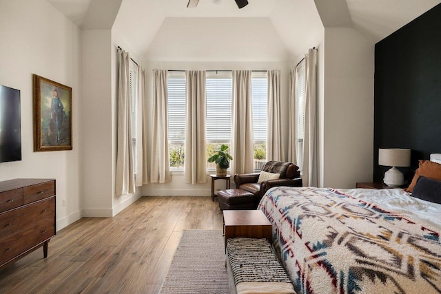 bedroom featuring vaulted ceiling, baseboards, and wood finished floors