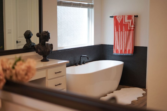 full bathroom featuring a freestanding tub and wainscoting