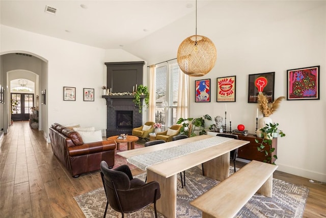296 Running Bird Rd, Austin, TX 78737 - dining room with vaulted ceiling, wood finished floors, visible vents, arched walkways, and a brick fireplace