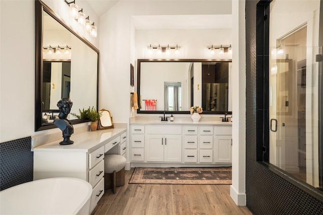 296 Running Bird Rd, Austin, TX 78737 - bathroom featuring a shower stall, wood finished floors, a sink, a freestanding tub, and double vanity