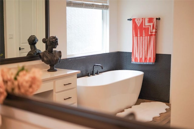 296 Running Bird Rd, Austin, TX 78737 - bathroom featuring a freestanding bath, tile walls, wainscoting, and vanity