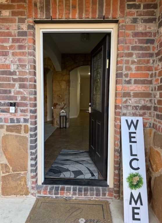 doorway to property featuring brick siding