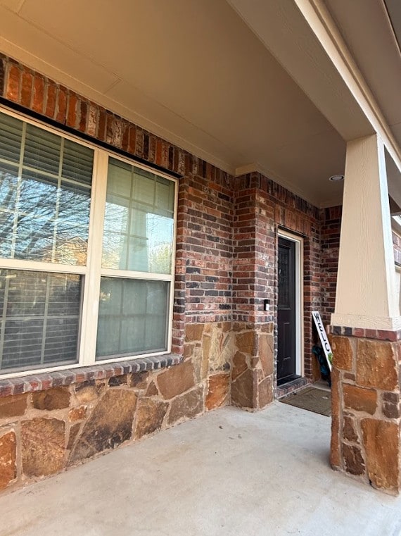 view of exterior entry featuring brick siding