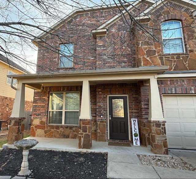 entrance to property featuring stone siding, a porch, an attached garage, and brick siding