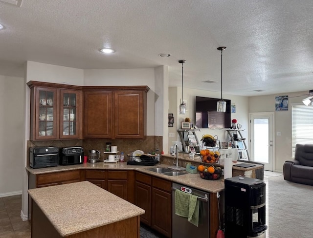 kitchen with dishwasher, open floor plan, a peninsula, light countertops, and a sink