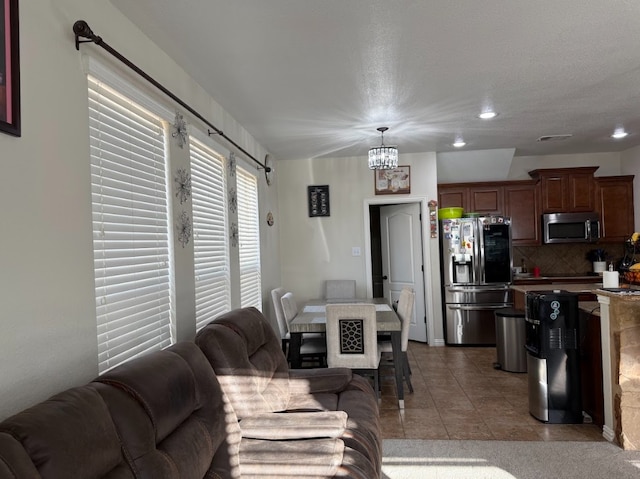 living room featuring tile patterned flooring, a notable chandelier, and recessed lighting