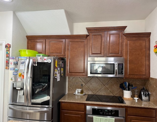 kitchen featuring a textured ceiling, appliances with stainless steel finishes, and backsplash