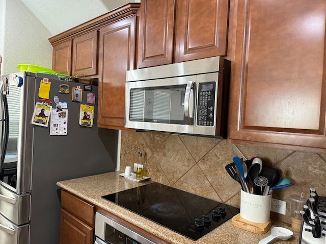 kitchen with appliances with stainless steel finishes, brown cabinetry, light countertops, and decorative backsplash