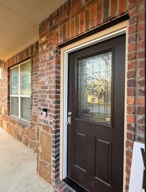 property entrance featuring brick siding