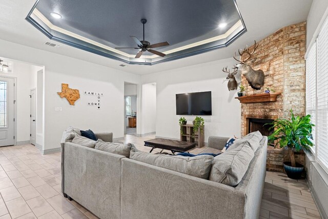 2807 Grimes Crossing Rd, Copperas Cove, TX 76522 - living room featuring a raised ceiling, ceiling fan, and a brick fireplace