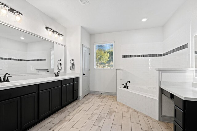 2807 Grimes Crossing Rd, Copperas Cove, TX 76522 - bathroom featuring a bath, double vanity, and wood finished floors