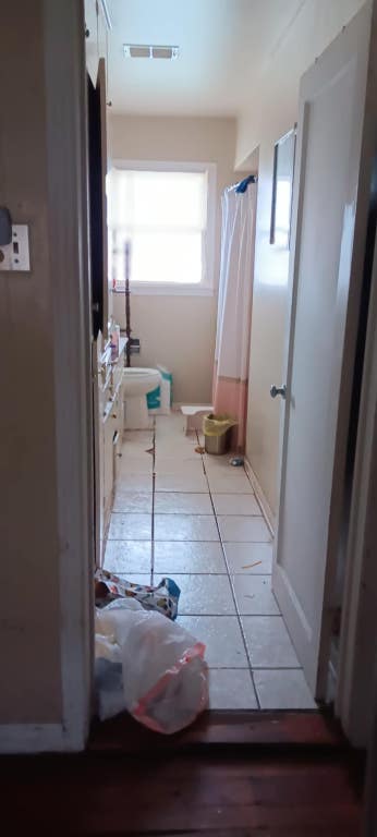 bathroom featuring a shower with shower curtain, vanity, visible vents, and tile patterned floors