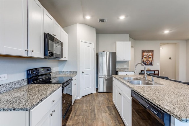 kitchen with dark wood finished floors, visible vents, white cabinets, a sink, and black appliances