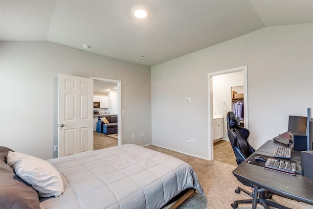 bedroom with baseboards, visible vents, connected bathroom, light colored carpet, and lofted ceiling