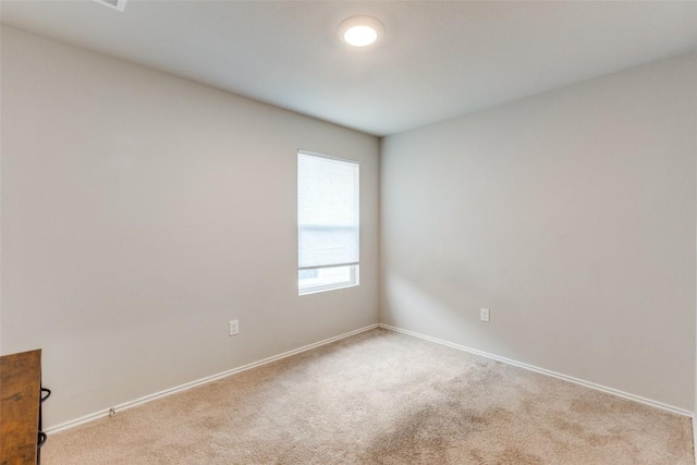 empty room featuring baseboards and carpet flooring