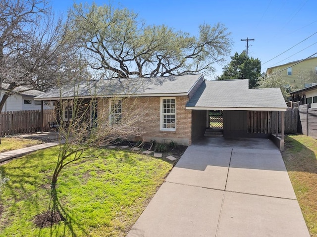 single story home with an attached carport, brick siding, fence, concrete driveway, and a front yard