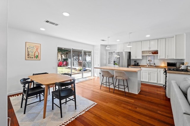 dining space with recessed lighting, visible vents, dark wood finished floors, and baseboards