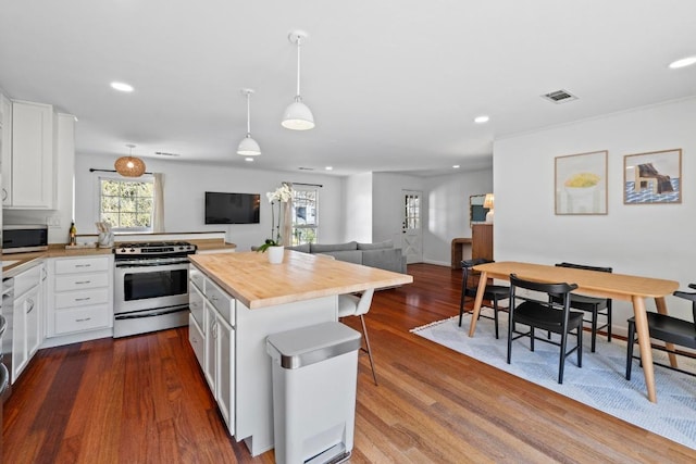 kitchen with dark wood-type flooring, wood counters, visible vents, white cabinets, and appliances with stainless steel finishes