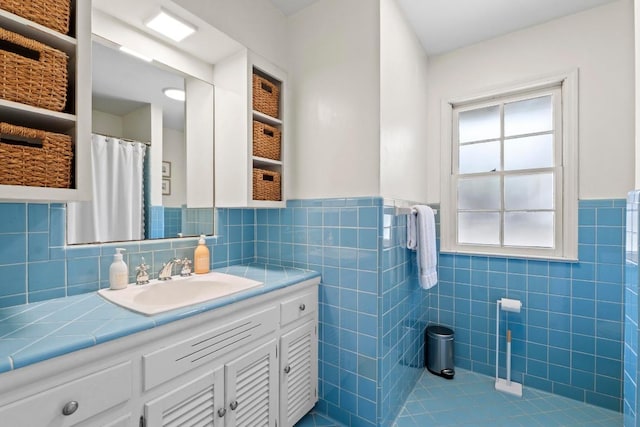 full bathroom featuring a wainscoted wall, vanity, and tile walls