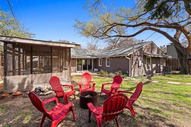 view of yard with an outdoor fire pit, a sunroom, cooling unit, and fence