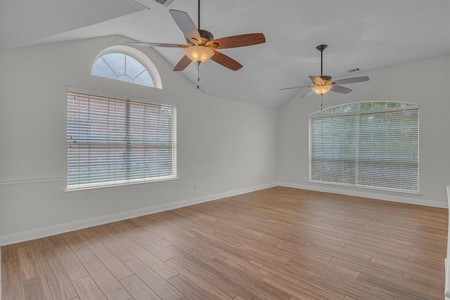 empty room with light wood-type flooring, lofted ceiling, and baseboards