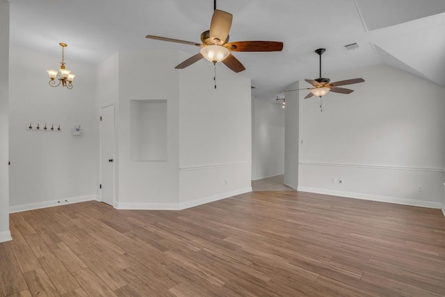 empty room featuring vaulted ceiling, baseboards, and light wood-style floors