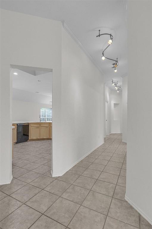 spare room featuring baseboards, track lighting, and light tile patterned floors