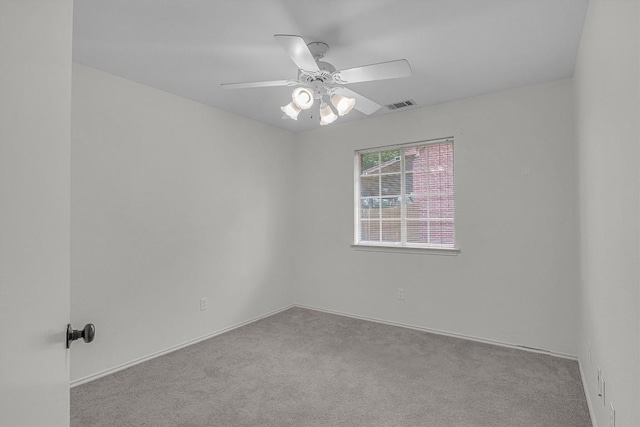 carpeted spare room with visible vents and ceiling fan