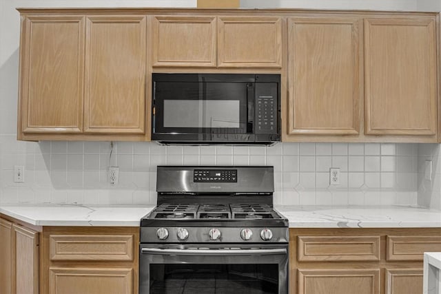 kitchen with black microwave, gas stove, and light brown cabinets