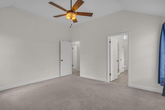 unfurnished bedroom featuring carpet floors, baseboards, connected bathroom, and lofted ceiling